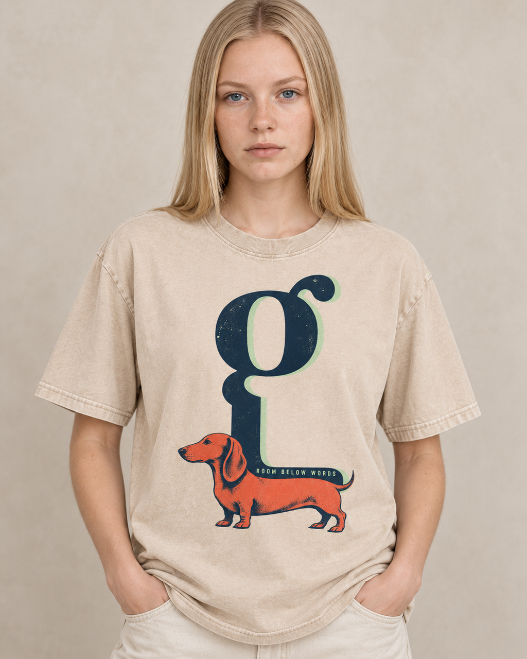 Adult model wears Apricot Dachshund Room Below Words Lowercase G washed T-shirt in a warm studio portrait