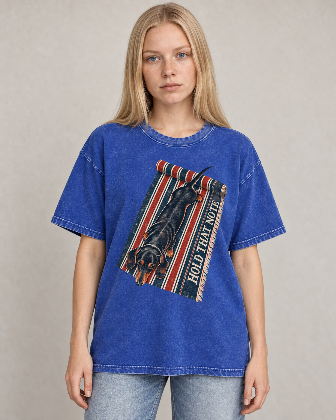 Adult model wears Royal Blue Dachshund Hold That Note Striped Rug washed T-shirt in a warm studio portrait