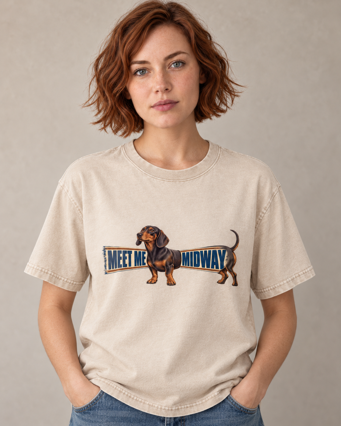 Adult model wears Apricot Dachshund Meet Me Midway Banner washed T-shirt in a warm studio portrait