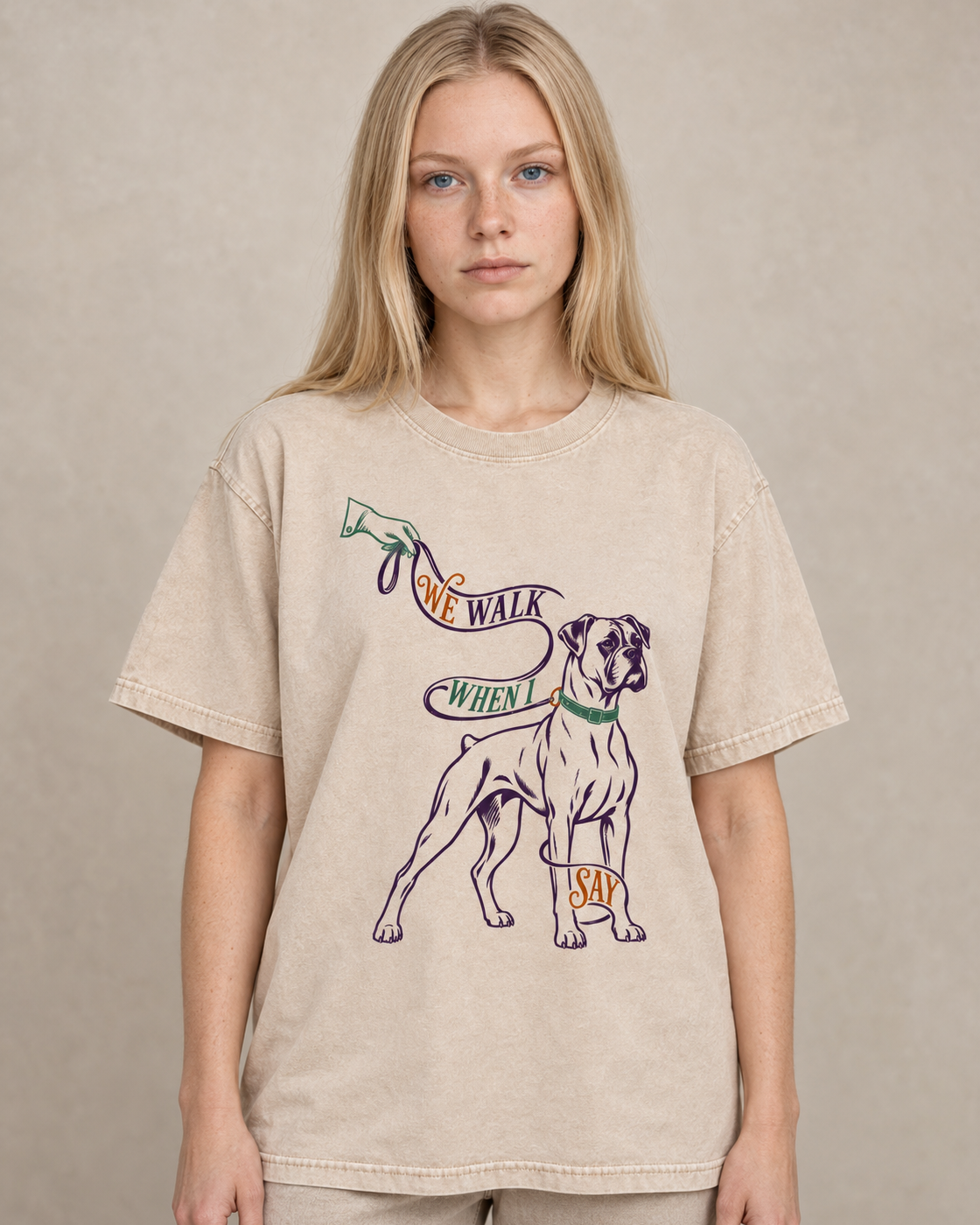 Adult model wears Apricot Boxer We Walk When I Say Leash washed T-shirt in a warm studio portrait