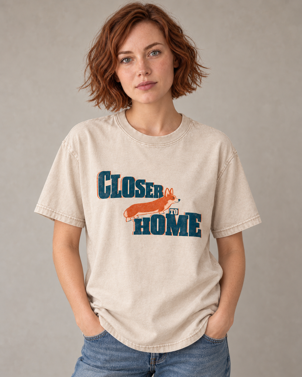 Adult model wears Apricot Corgi Closer to Home Typographic washed T-shirt in a warm studio portrait