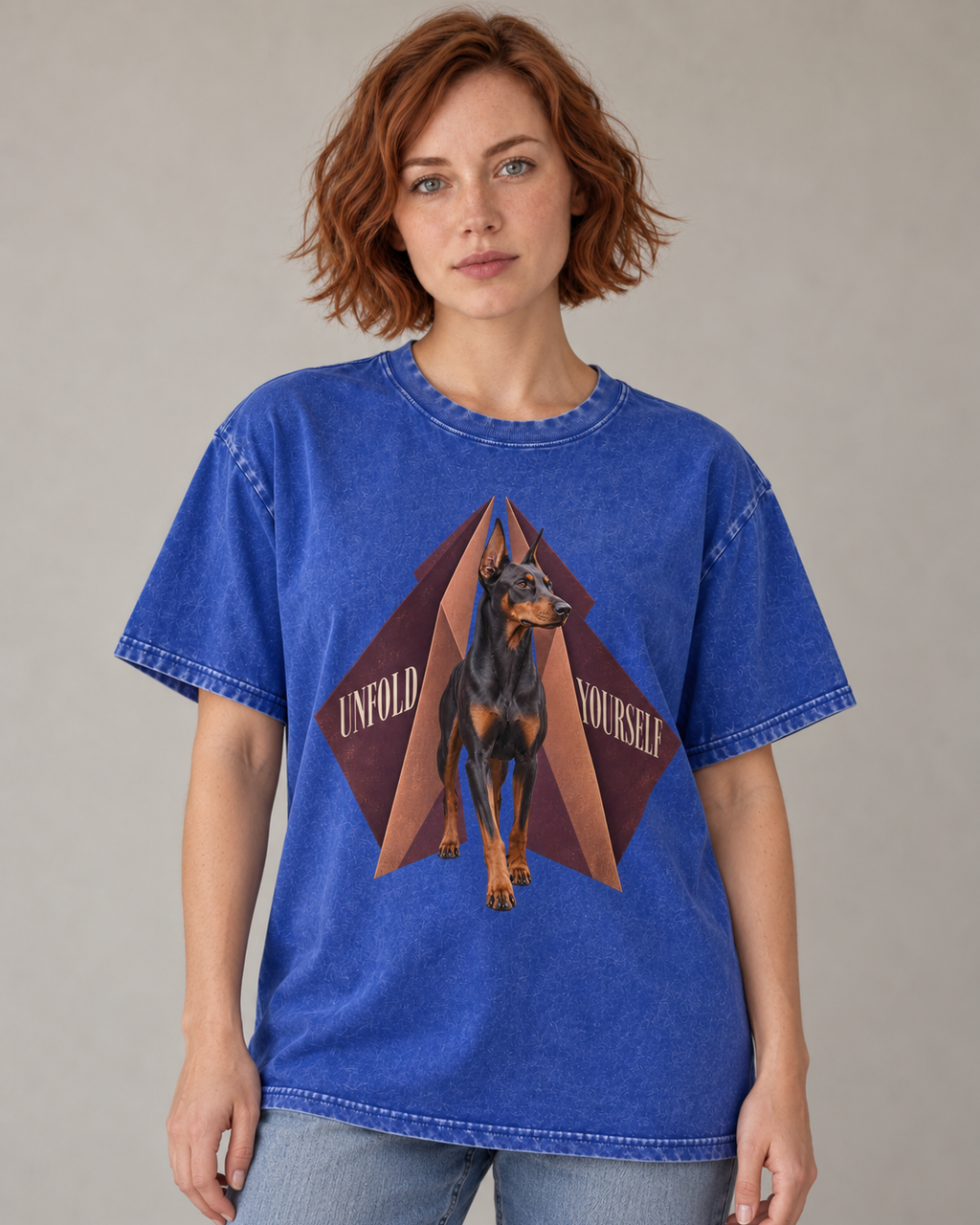 Adult model wears Royal Blue Doberman Unfold Yourself Geometric Portrait washed T-shirt in a warm studio portrait