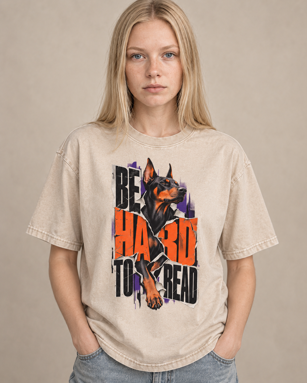 Adult model wears Apricot Doberman Be Hard to Read Torn Poster washed T-shirt in a warm studio portrait
