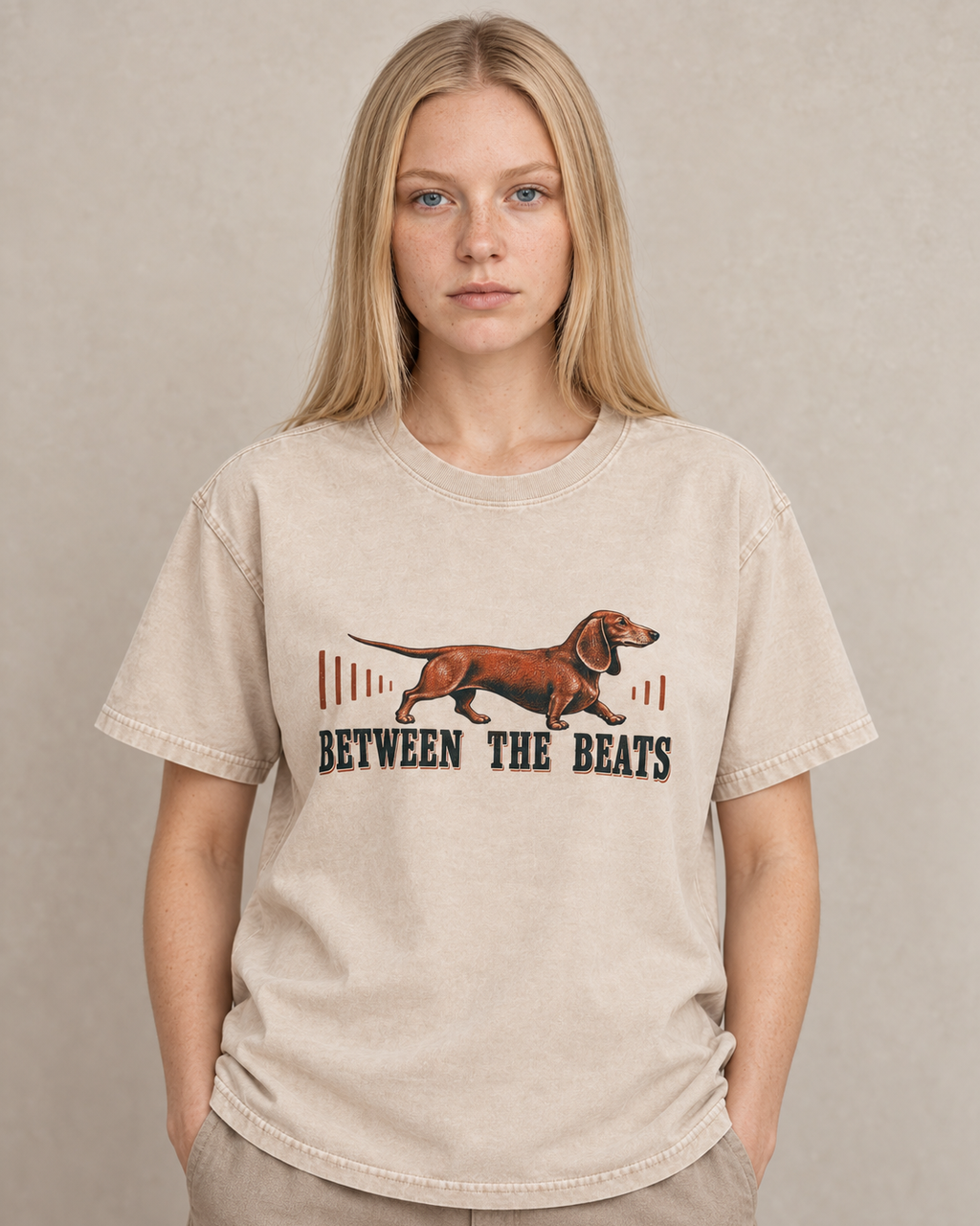 Adult model wears Apricot Dachshund Between The Beats Audio Wave washed T-shirt in a warm studio portrait