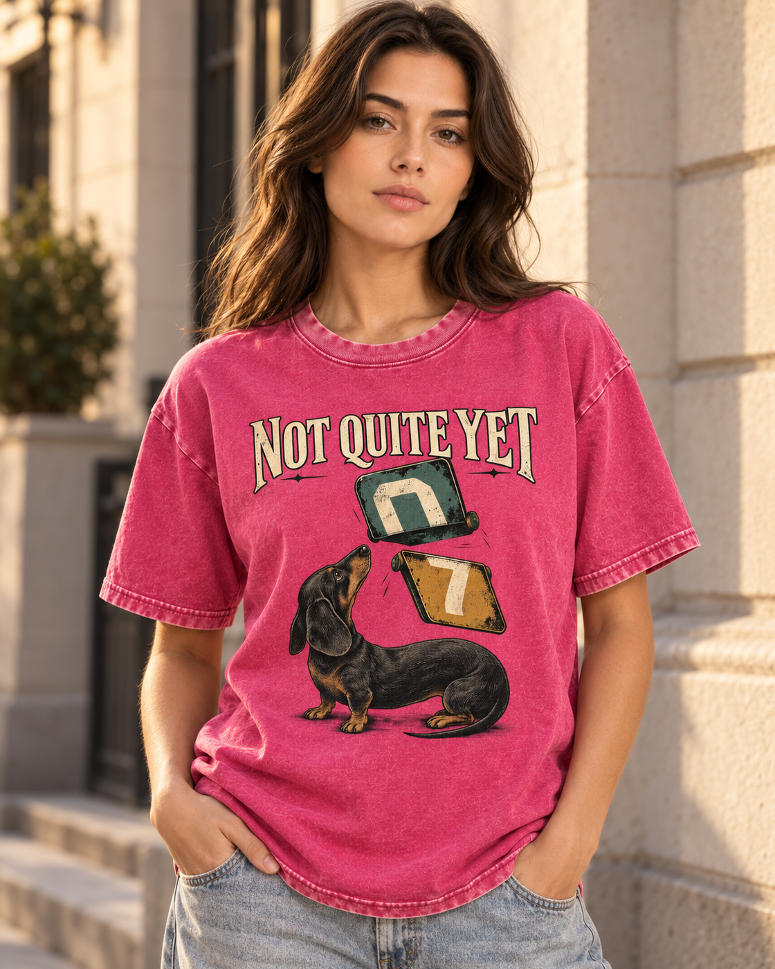 Adult model wears Fuchsia Dachshund Not Quite Yet Flip Cards washed T-shirt in a three-quarter street portrait