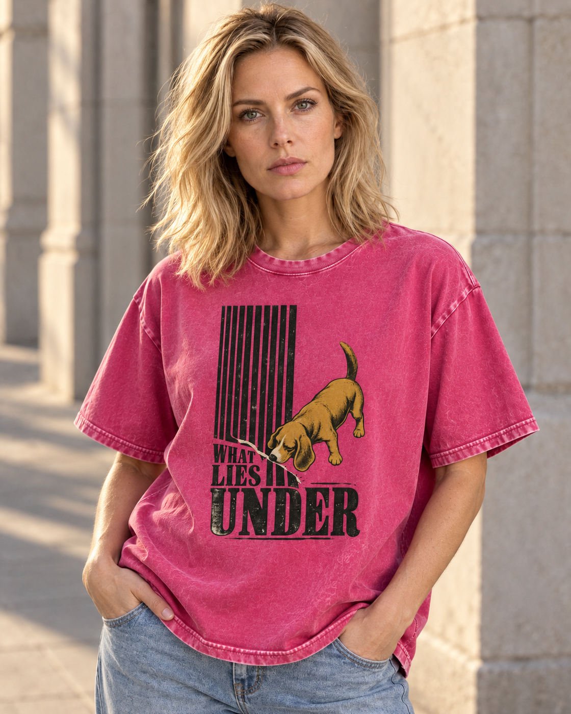 Adult model wears Fuchsia Beagle Curious What Lies Under washed T-shirt in a three-quarter street portrait
