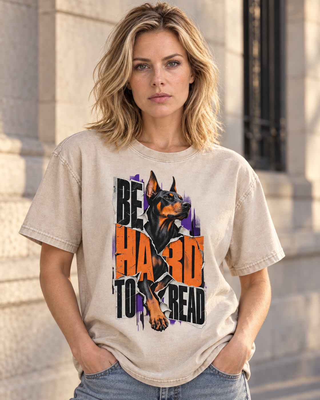 Adult model wears Apricot Doberman Be Hard to Read Torn Poster washed T-shirt in a three-quarter street portrait