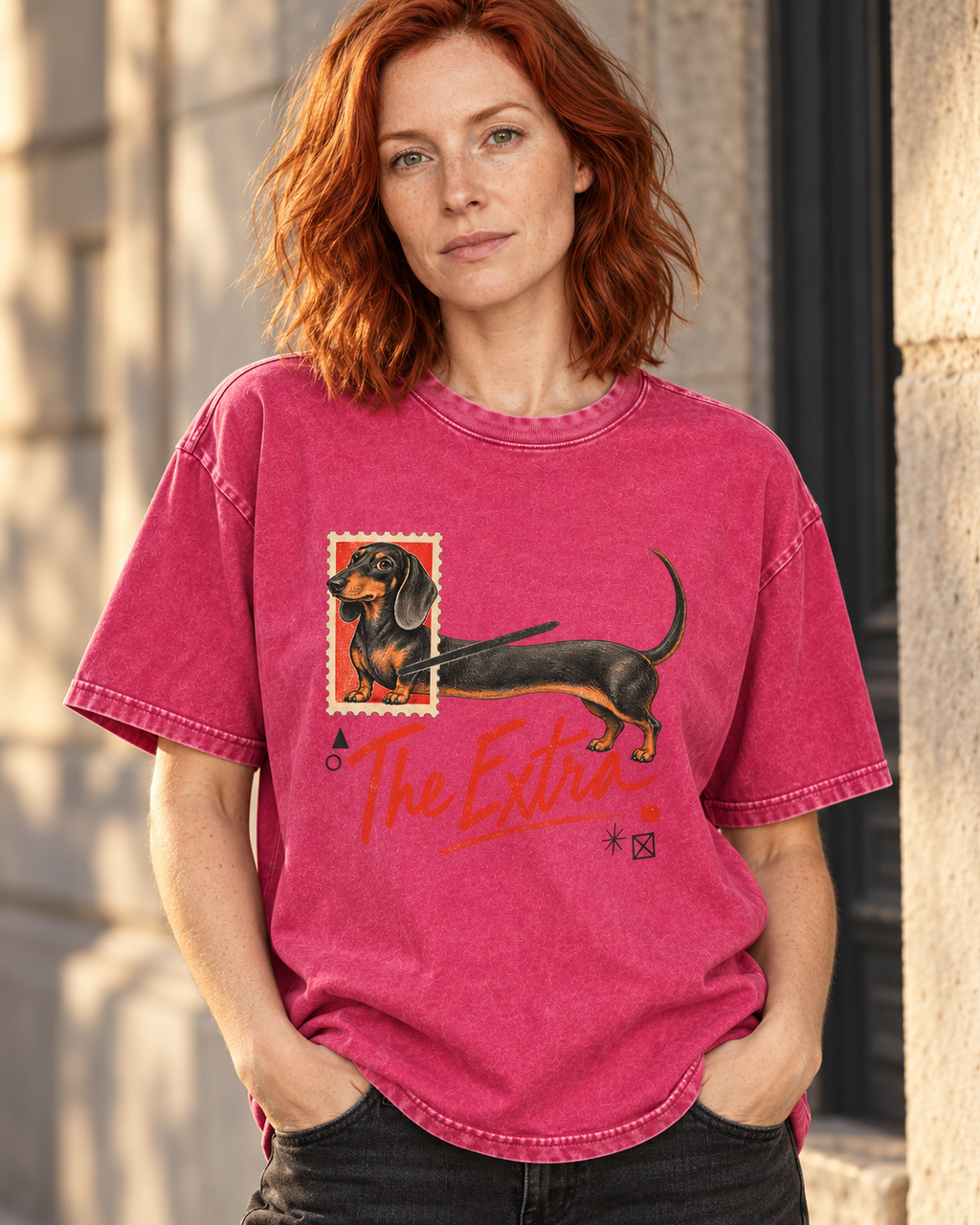 Adult model wears Fuchsia Dachshund The Extra Postage washed T-shirt in a three-quarter street portrait
