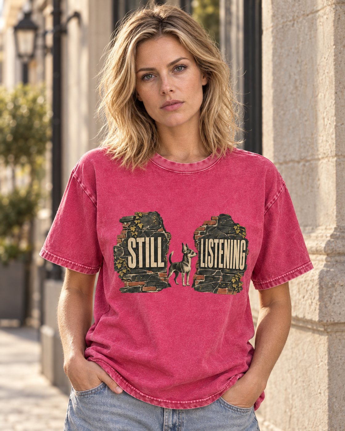 Adult model wears Fuchsia Chihuahua Still Listening washed T-shirt in a three-quarter street portrait