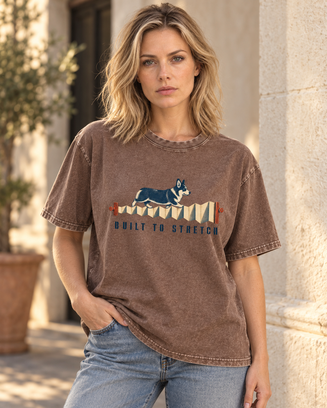 Adult model wears Coffee Corgi Built to Stretch Accordion washed T-shirt in a three-quarter street portrait