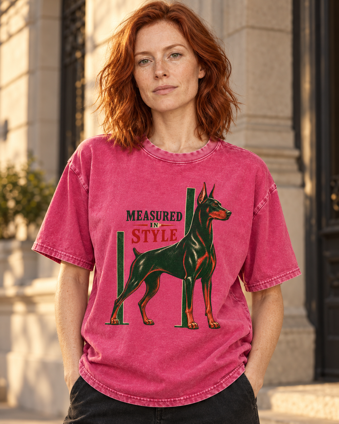 Adult model wears Fuchsia Doberman Measured in Style Column washed T-shirt in a three-quarter street portrait