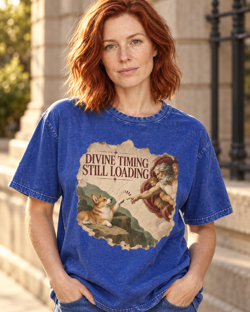 Adult model wears Royal Blue Corgi Divine Timing Still Loading Creation Parody washed T-shirt in a three-quarter street port