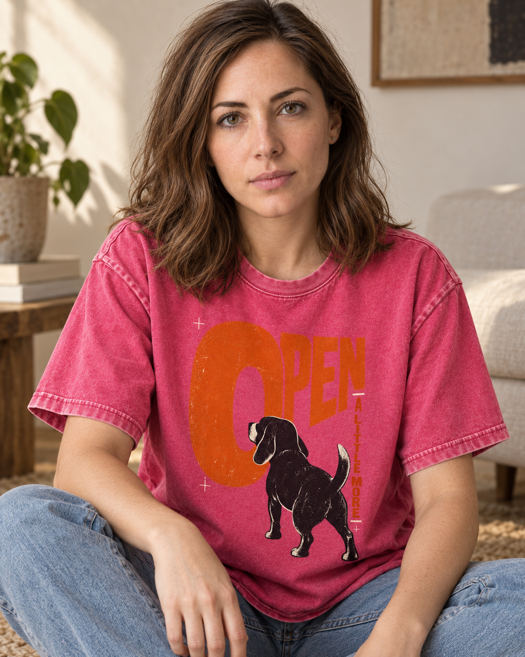 Adult model wears Fuchsia Beagle Open A Little More washed T-shirt in a seated indoor portrait
