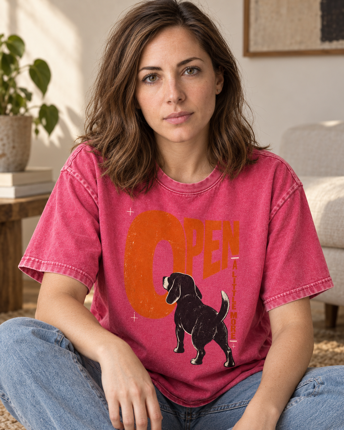 Adult model wears Fuchsia Beagle Open A Little More washed T-shirt in a seated indoor portrait