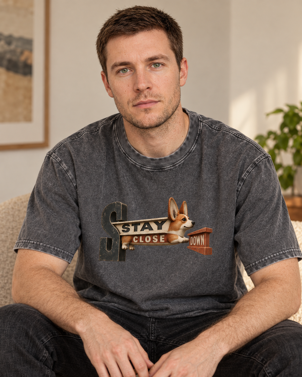 Adult model wears Gray Corgi Stay Close Down Sign washed T-shirt in a seated indoor portrait