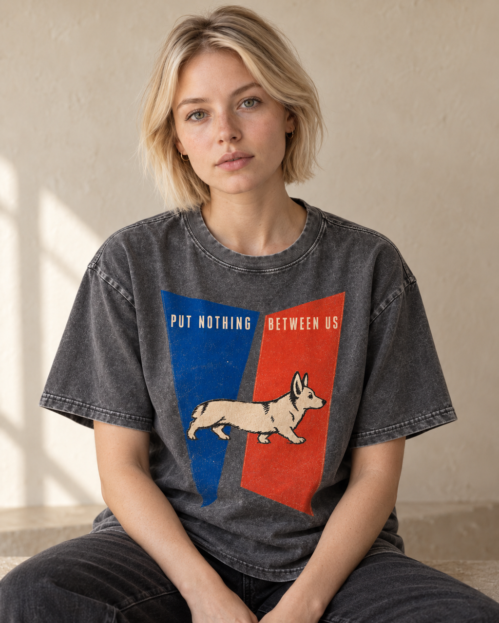 Adult model wears Gray Corgi Put Nothing Between Us Split Panels washed T-shirt in a seated indoor portrait