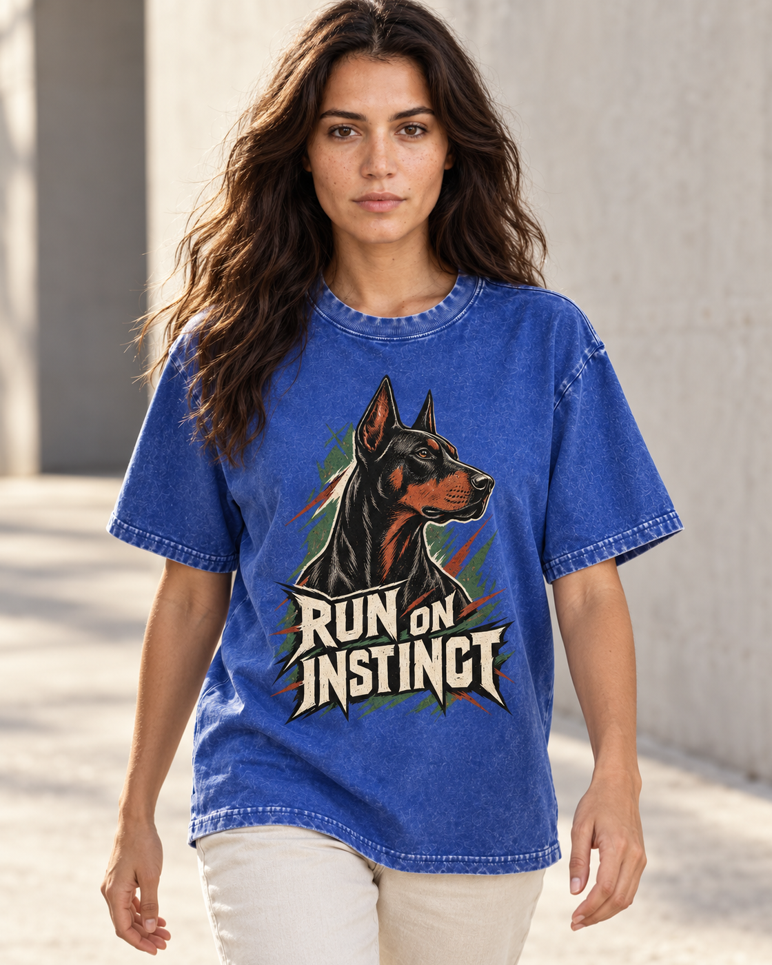 Adult model wears Royal Blue Doberman Run on Instinct Brush Slash washed T-shirt in a natural walking portrait