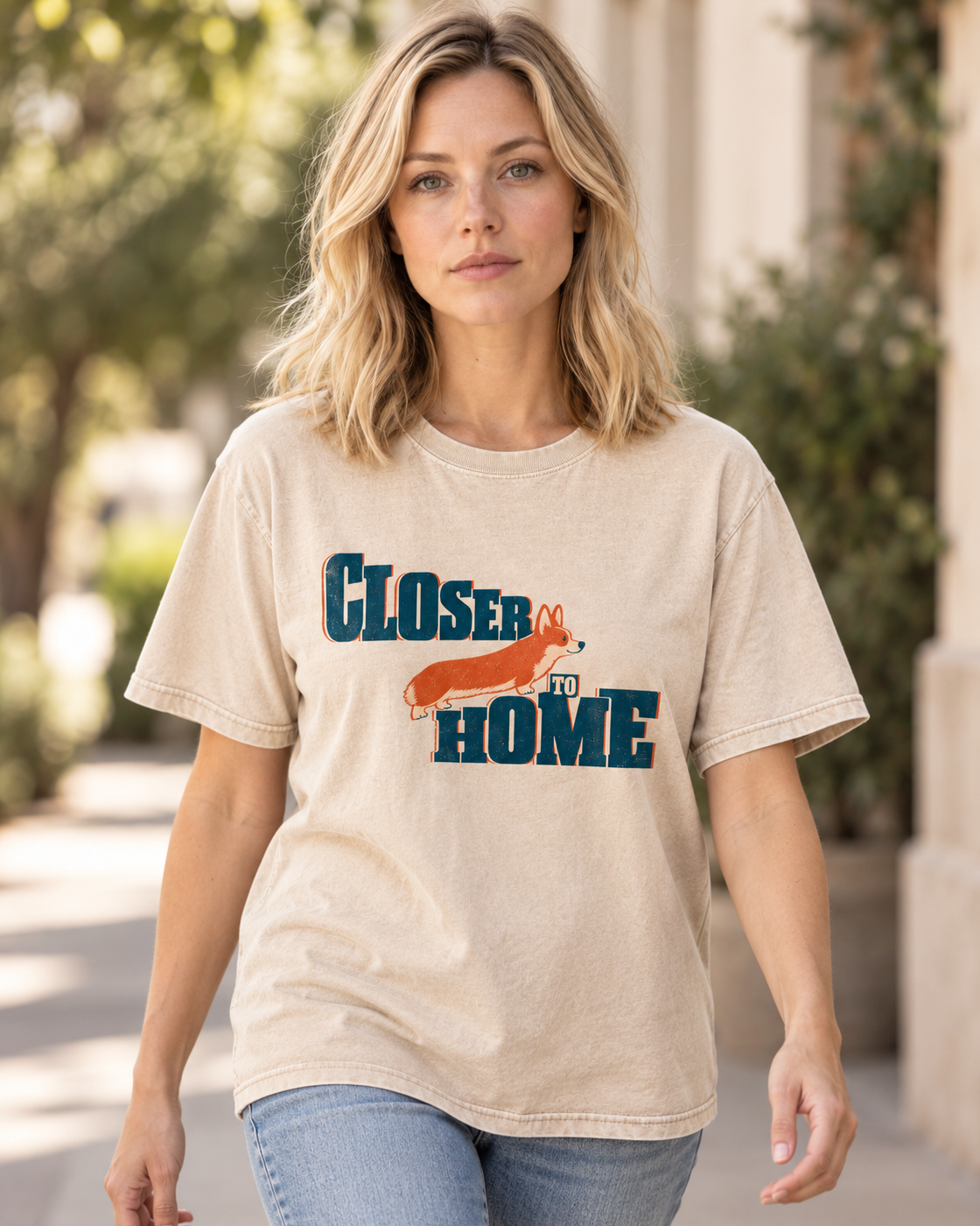 Adult model wears Apricot Corgi Closer to Home Typographic washed T-shirt in a natural walking portrait