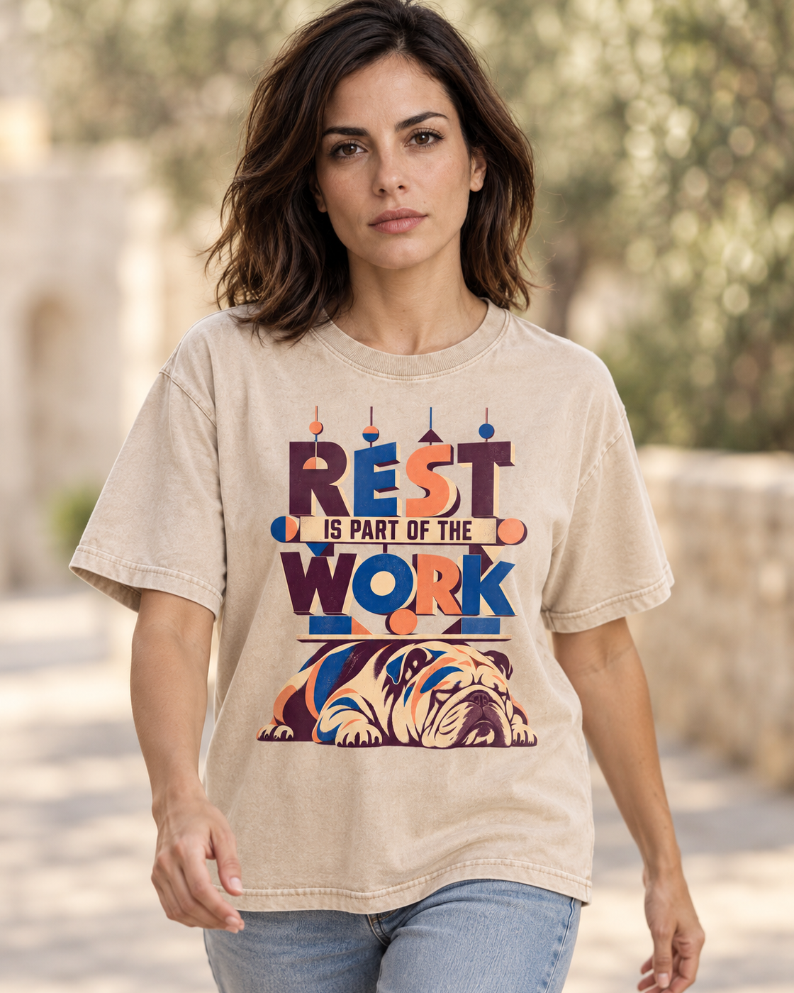 Adult model wears Apricot English Bulldog Rest Is Part of the Work Geometric washed T-shirt in a natural walking portrait