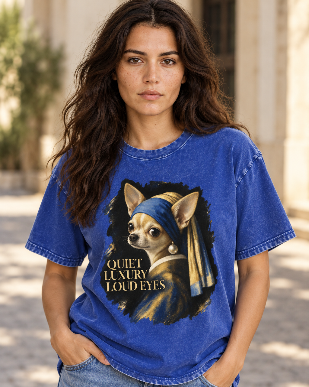 Adult model wears Royal Blue Chihuahua Quiet Luxury Loud Eyes Pearl Earring Portrait washed T-shirt in a natural walking por