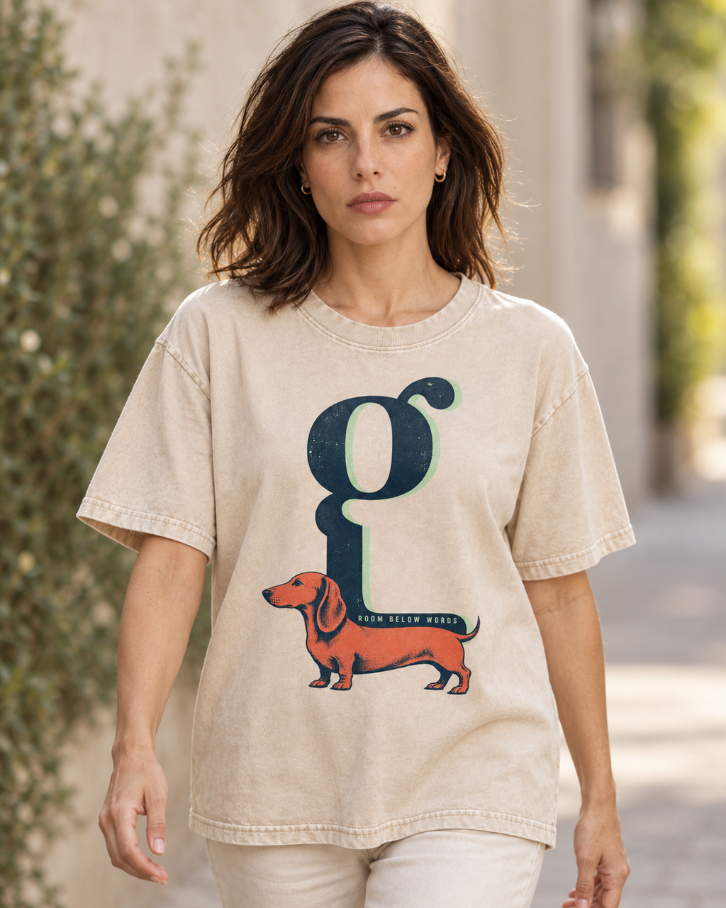 Adult model wears Apricot Dachshund Room Below Words Lowercase G washed T-shirt in a natural walking portrait