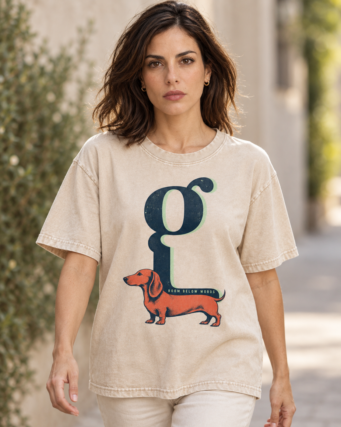 Adult model wears Apricot Dachshund Room Below Words Lowercase G washed T-shirt in a natural walking portrait