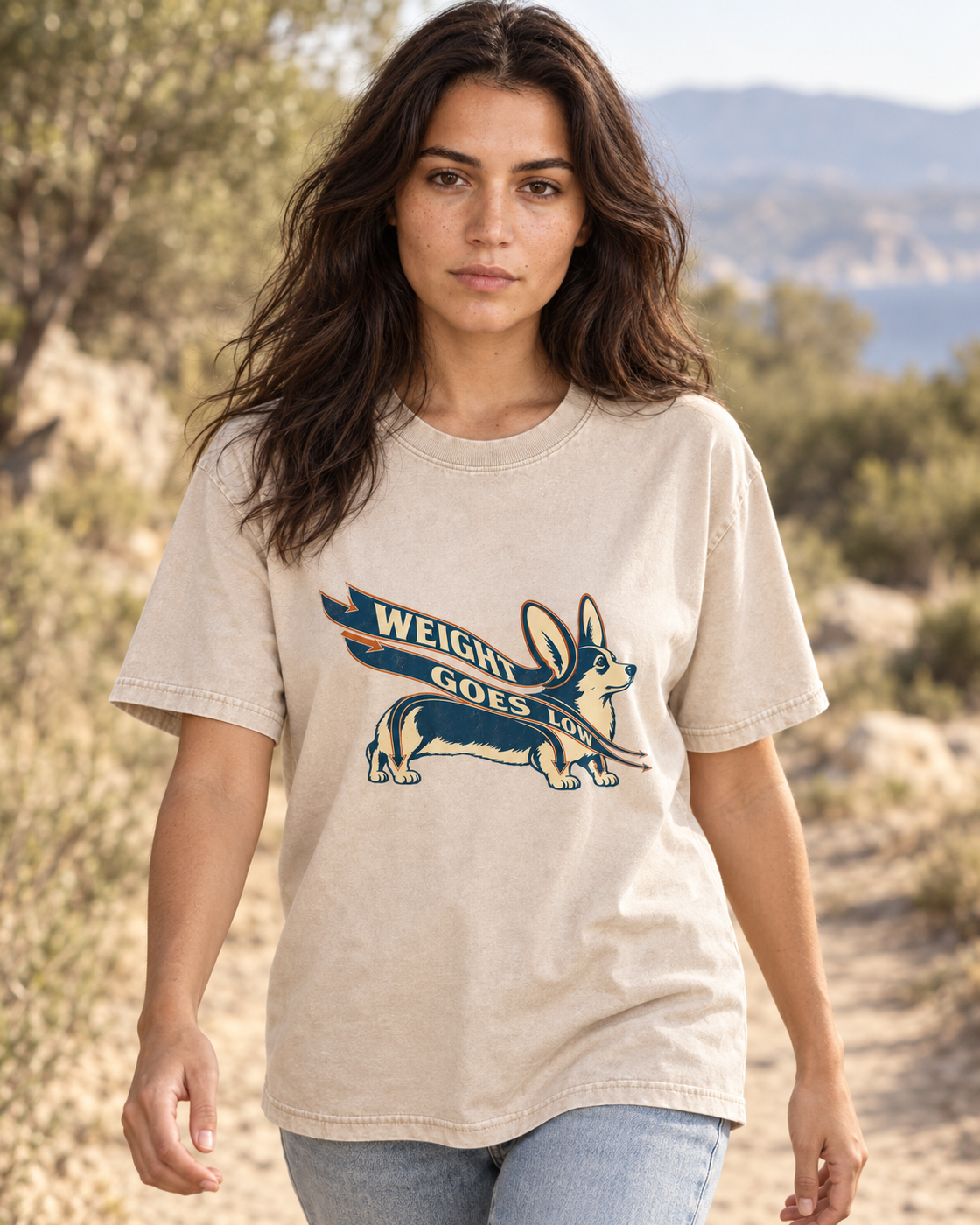 Adult model wears Apricot Corgi Weight Goes Low Ribbon Arrow washed T-shirt in a natural walking portrait