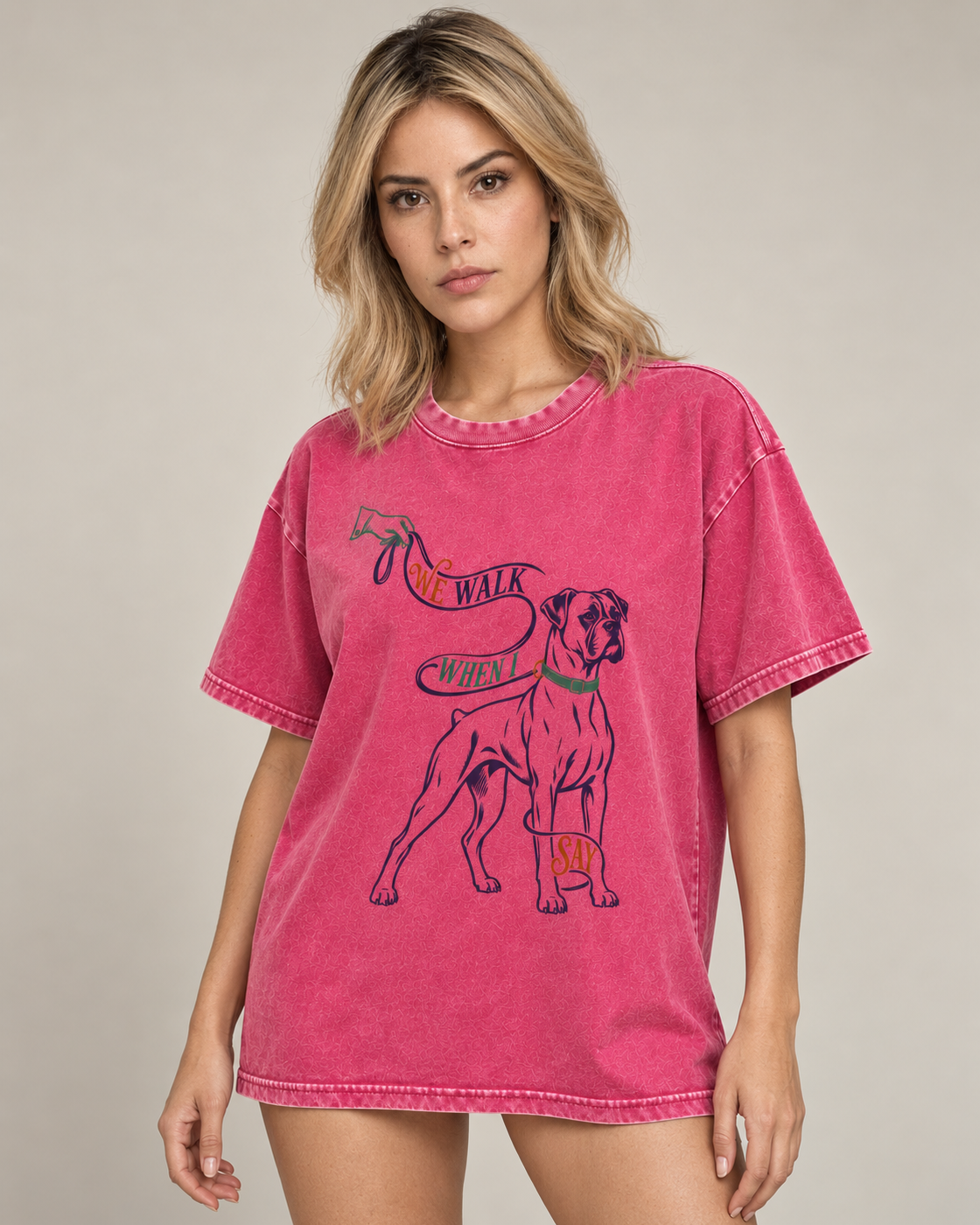 Adult model wears Fuchsia Boxer We Walk When I Say Leash washed T-shirt in a side-angle editorial portrait