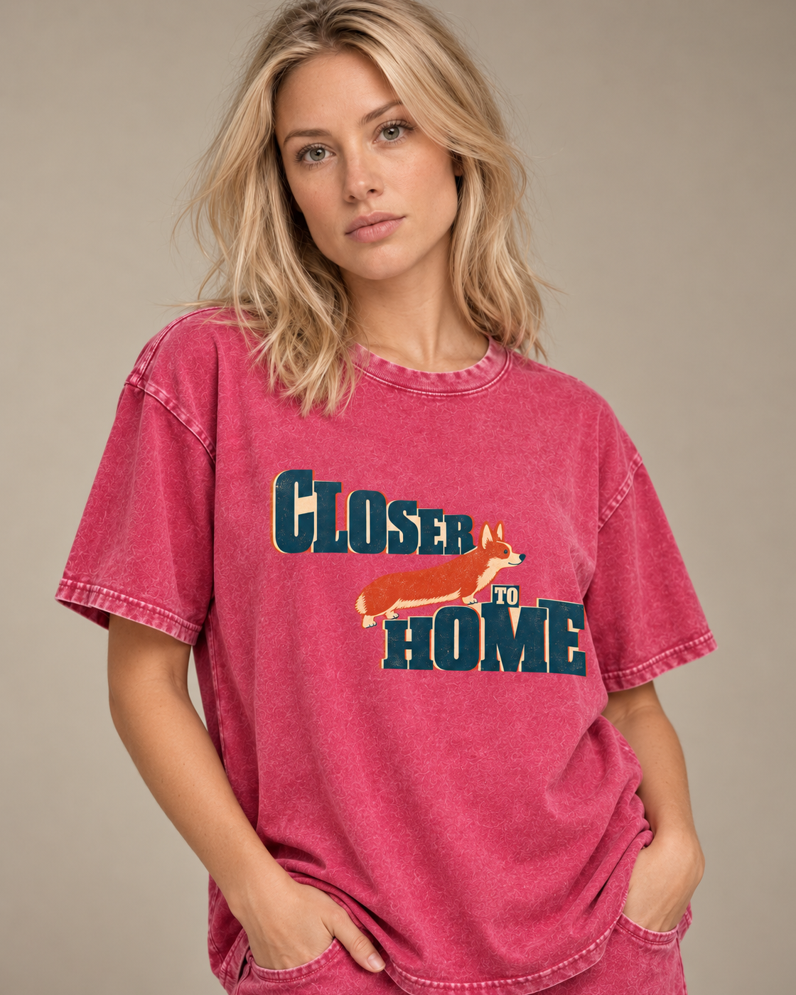 Adult model wears Fuchsia Corgi Closer to Home Typographic washed T-shirt in a side-angle editorial portrait