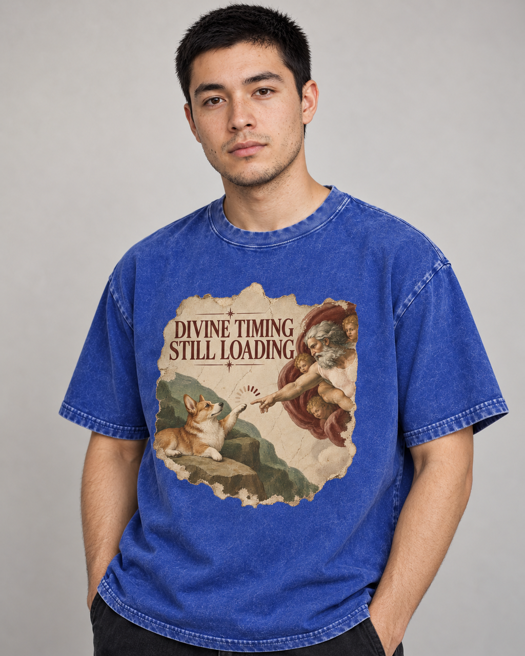 Adult model wears Royal Blue Corgi Divine Timing Still Loading Creation Parody washed T-shirt in a side-angle editorial port