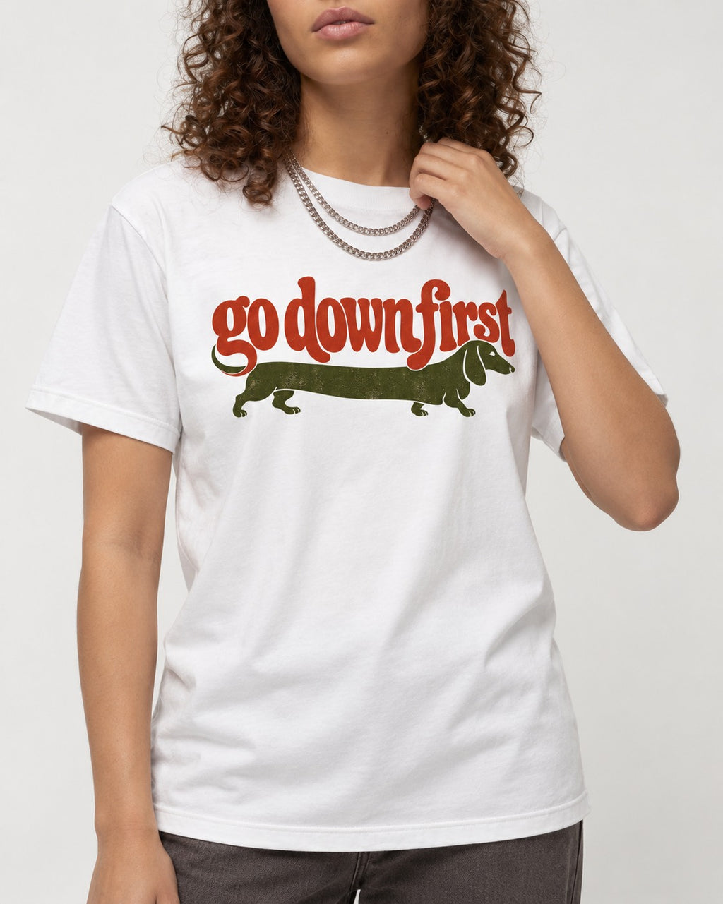 Dachshund Goes Down First T-Shirt in White, worn by a model, front view