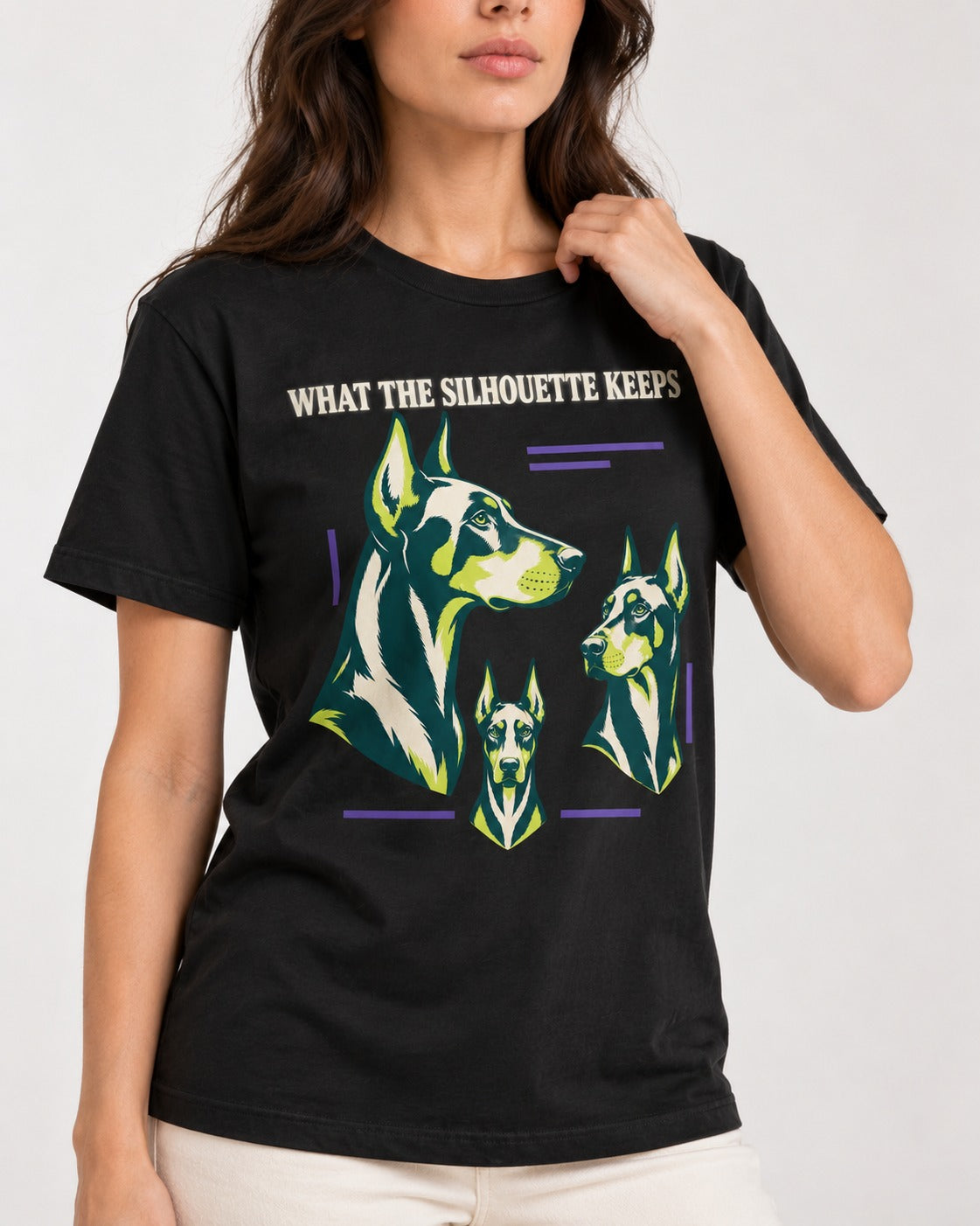 Doberman What the Silhouette Keeps Three Portrait Graphic T-Shirt in Black, worn by a model, front view