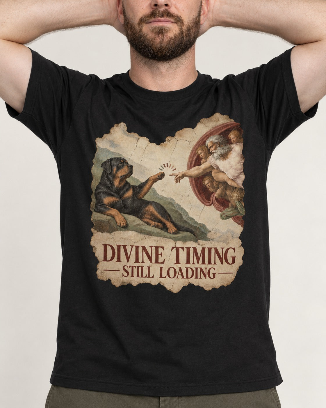 Rottweiler Divine Timing Still Loading Creation Parody Graphic T-Shirt in Black, worn by a model, front view