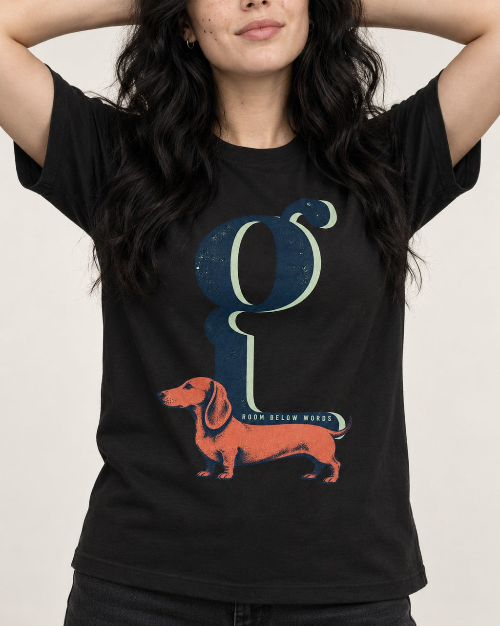 Dachshund Room Below Words Lowercase G Graphic T-Shirt in Black, worn by a model, front view