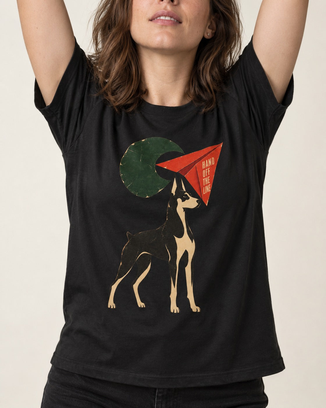 Doberman Hand Off the Line Paper Plane Graphic T-Shirt in Black, worn by a model, front view