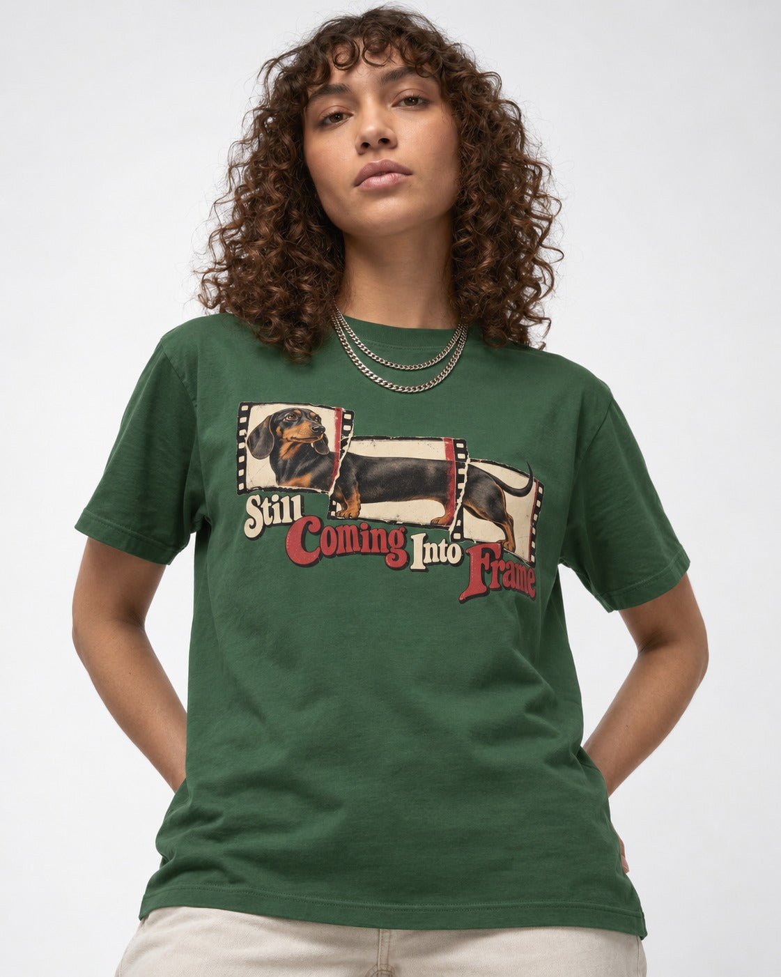 Dachshund Still Coming Into Frame Vintage Filmstrip Graphic T-Shirt in Forest Green, worn by a model