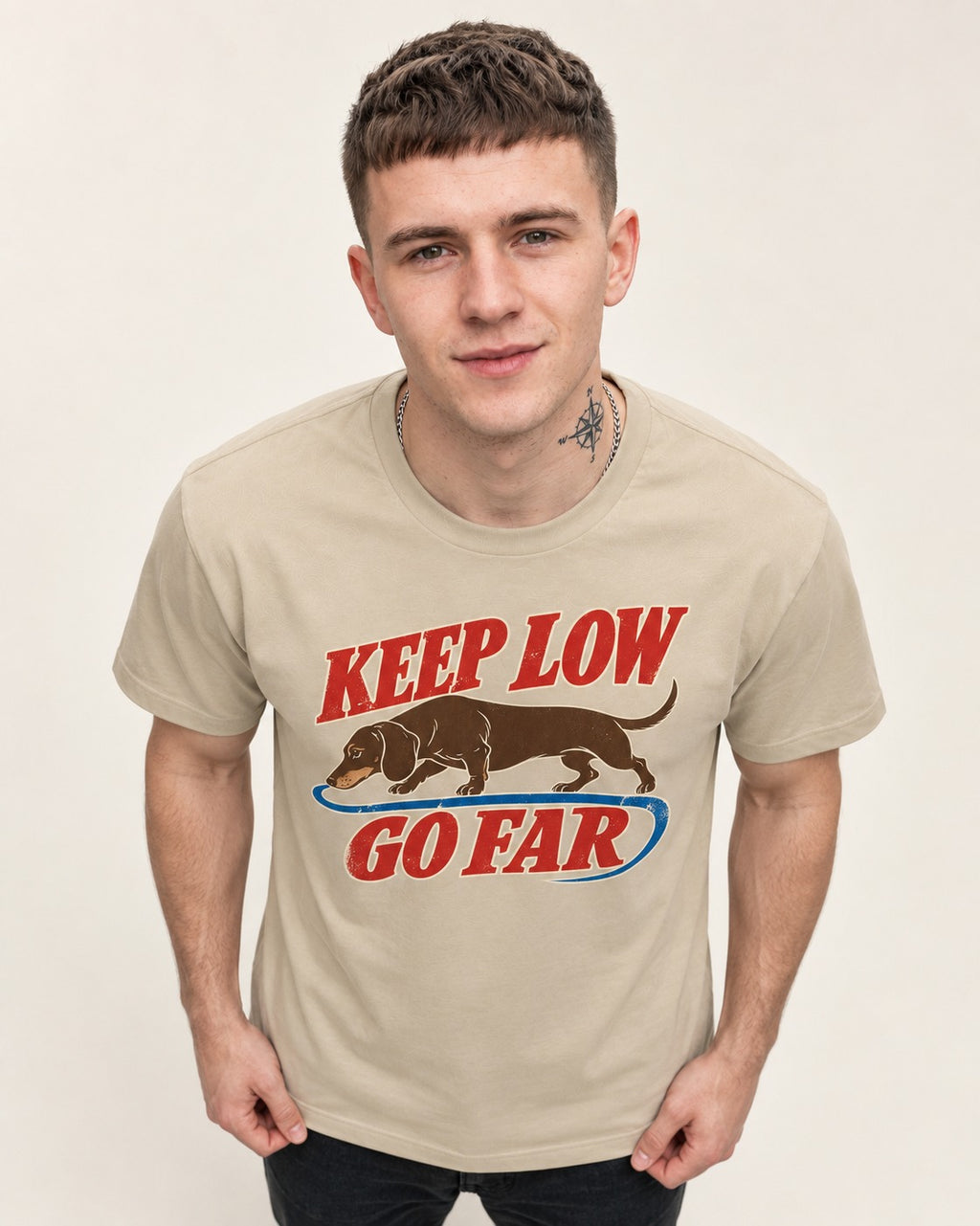 Dachshund Keep Low Go Far T-Shirt in Sand, worn by a model