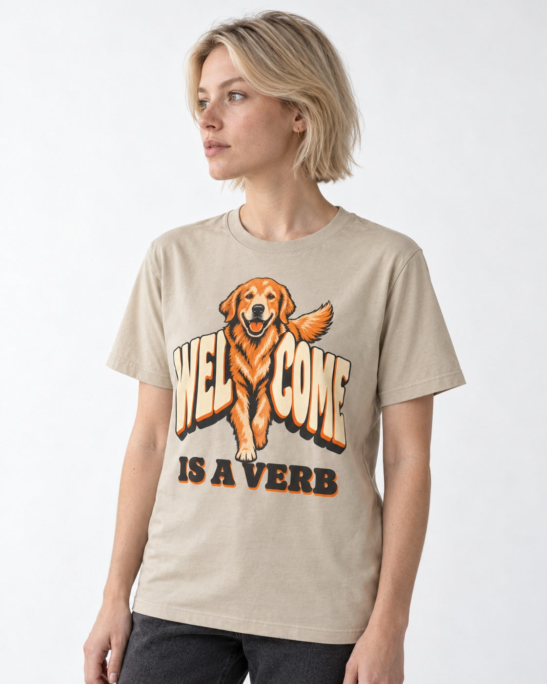 Golden Retriever Welcome Is a Verb T-Shirt in Sand, worn by a model