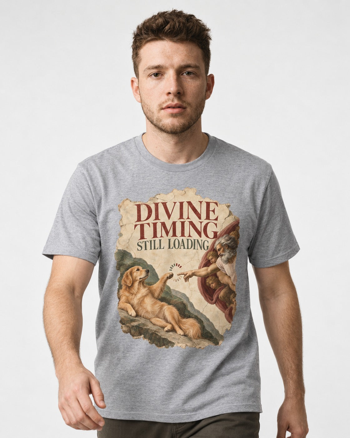 Divine Timing Still Loading Creation Scene Golden Retriever Graphic T-Shirt in Sport Grey, worn by a model