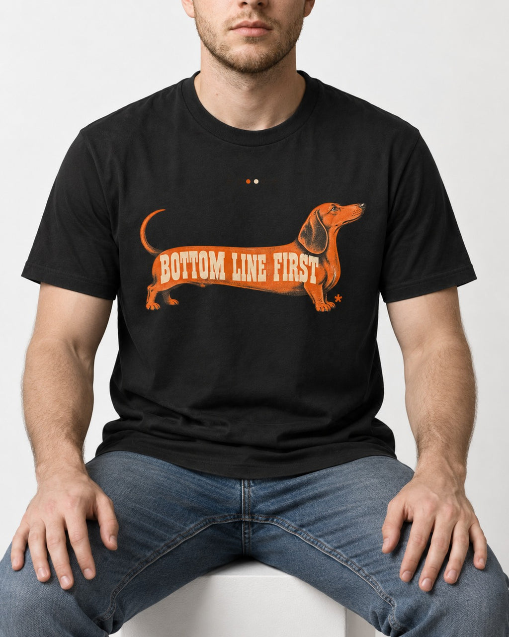 Dachshund Bottom Line First Body Lettering Graphic T-Shirt in Black, worn by a seated model