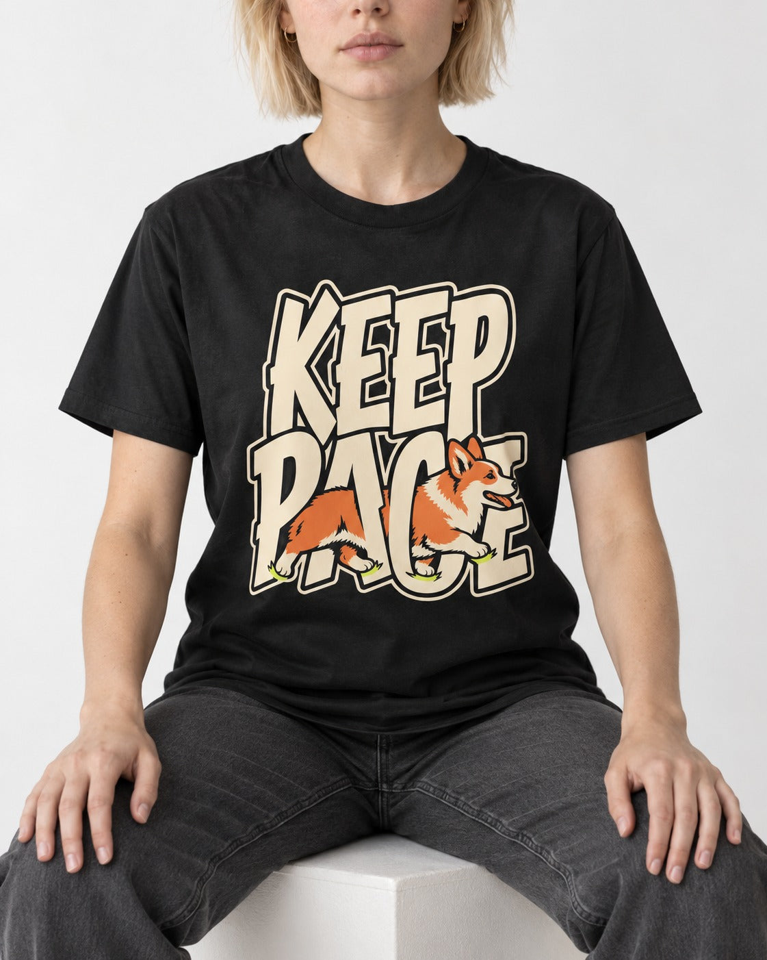 Corgi Keep Pace Running Typographic Graphic T-Shirt in Black, worn by a seated model