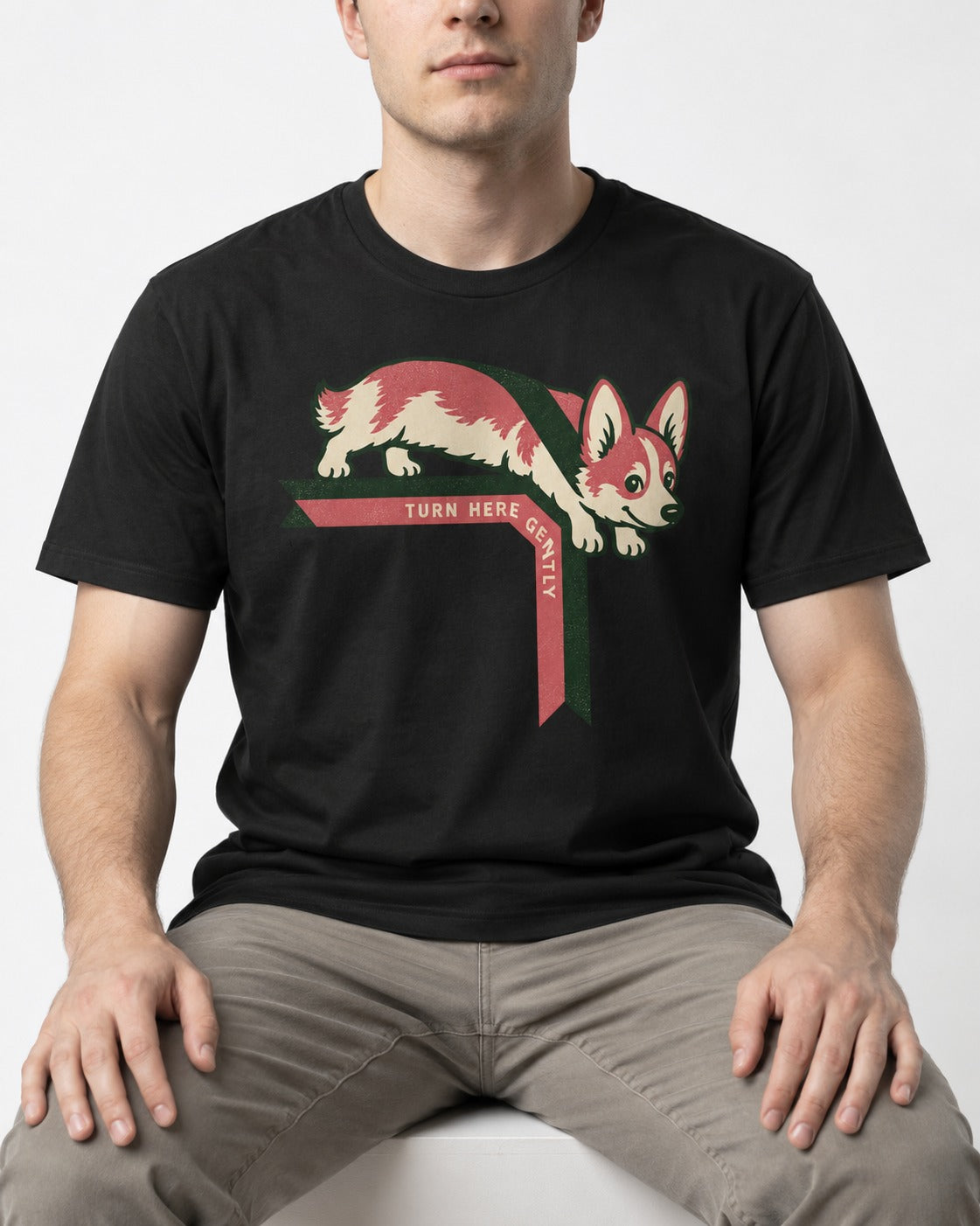 Corgi Turn Here Gently T-Shirt in Black, worn by a seated model