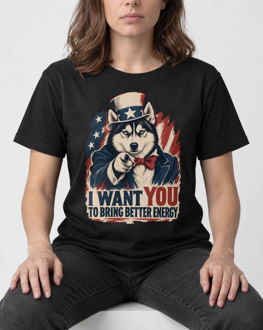 Husky I Want You to Bring Better Energy Patriotic Poster Graphic T-Shirt in Black, worn by a seated model