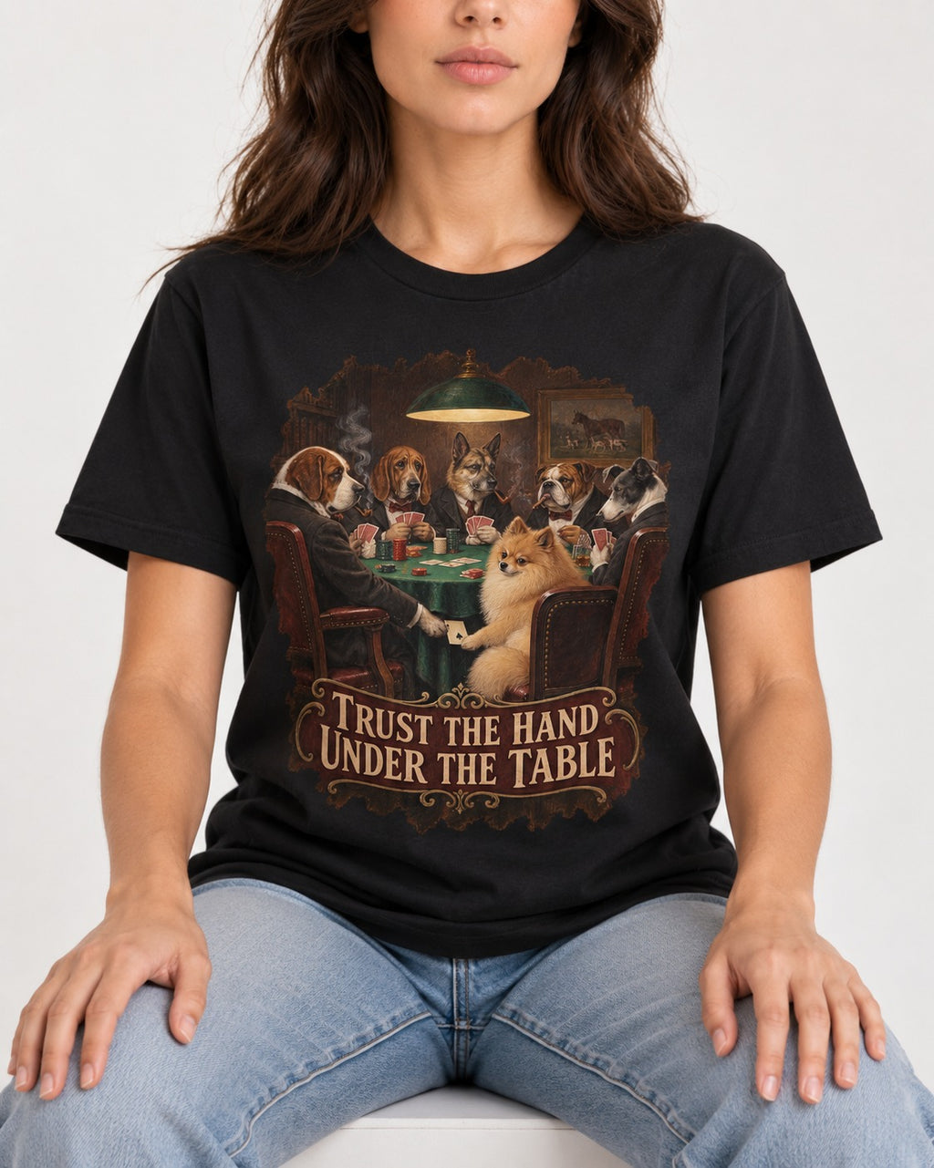 Pomeranian Trust the Hand Under the Table Poker Dogs Graphic T-Shirt in Black, worn by a seated model