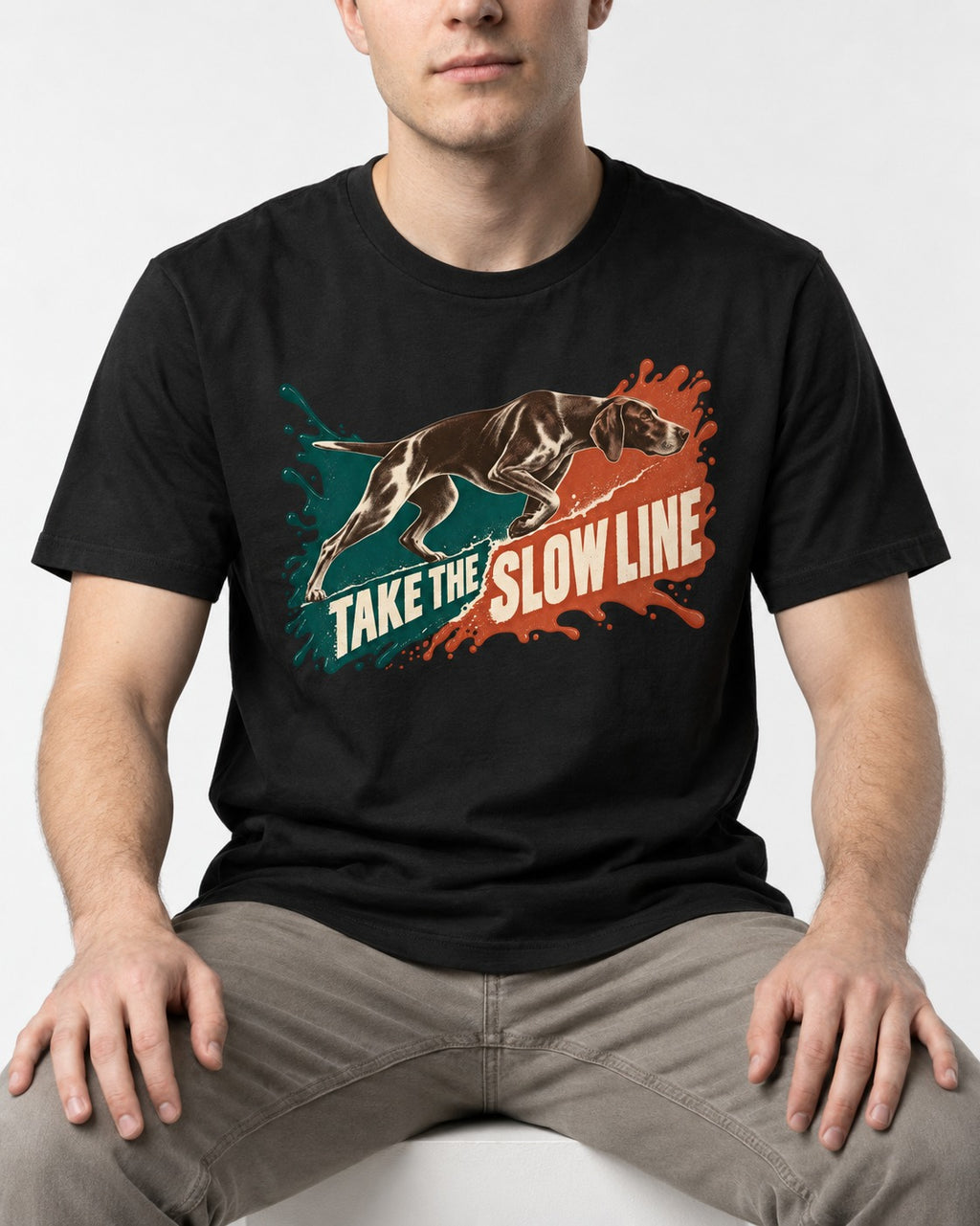 German Shorthaired Pointer Take The Slow Line Paint Splash Graphic T-Shirt in Black, worn by a seated model