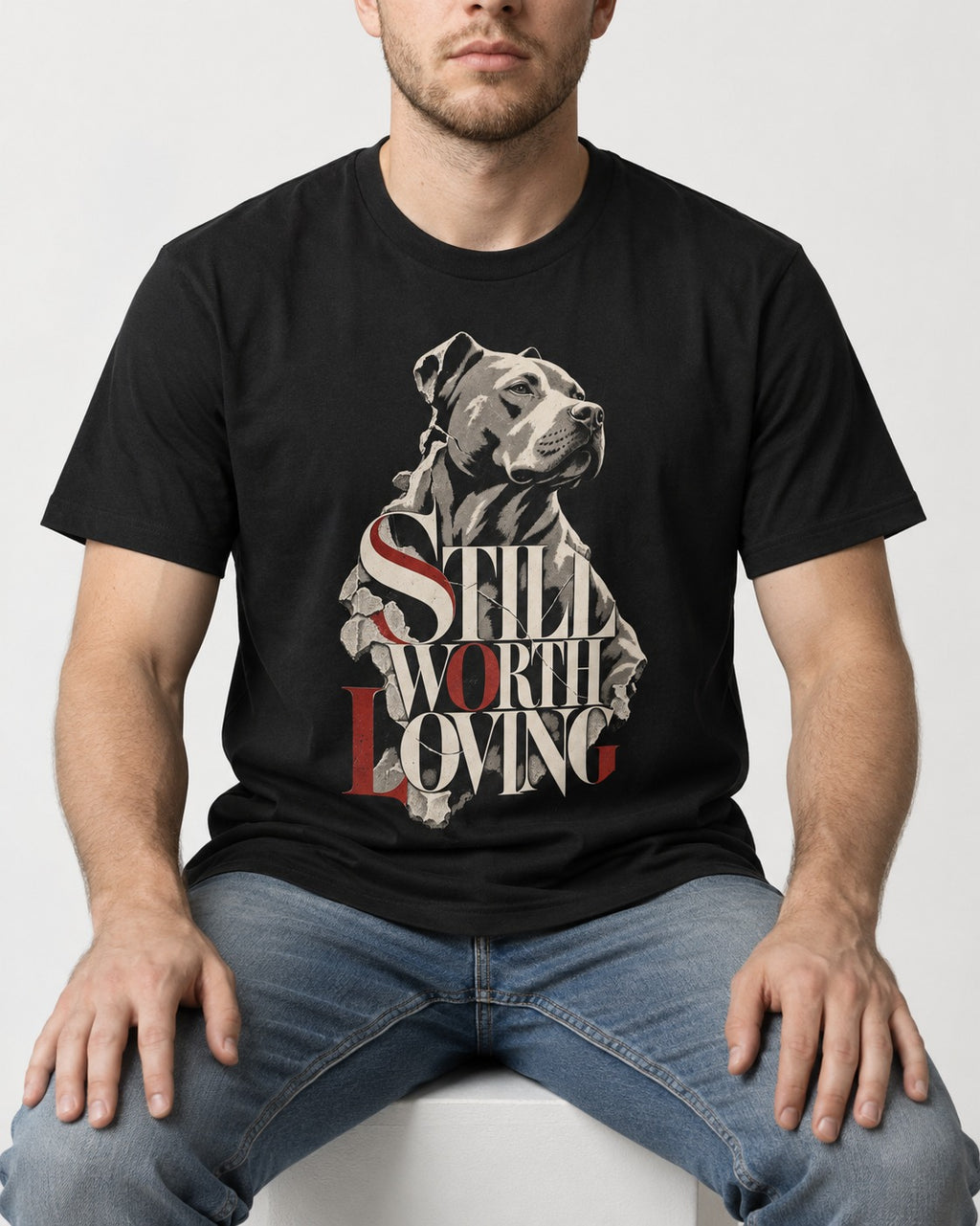 Pitbull Still Worth Loving Torn Poster Portrait Graphic T-Shirt in Black, worn by a seated model