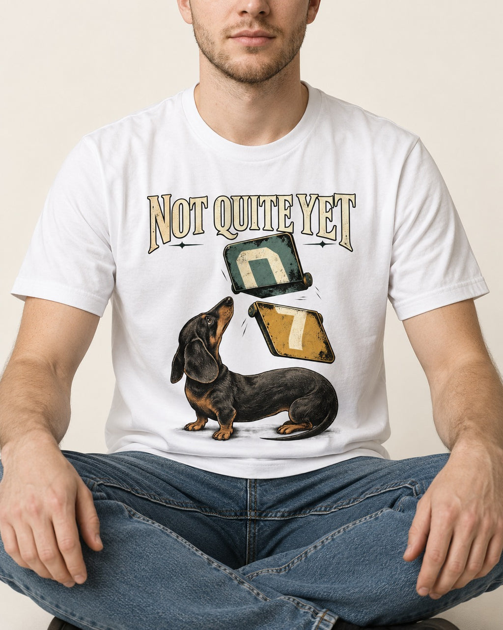 Not Quite Yet Dachshund T-Shirt in White, worn by a seated model