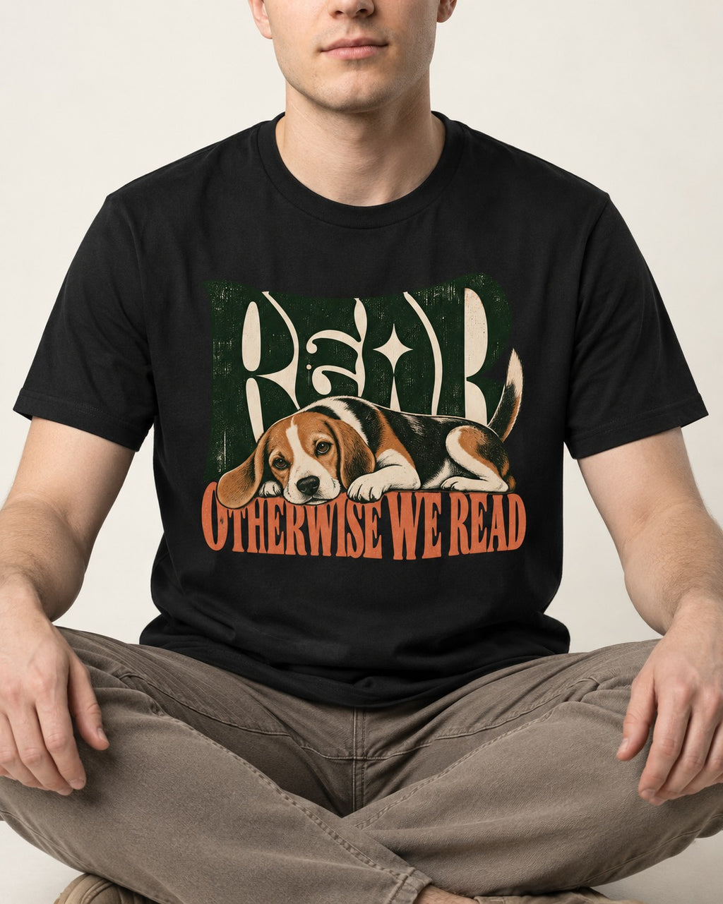 Beagle Read Otherwise We Read Retro Graphic T-Shirt in Black, worn by a seated model