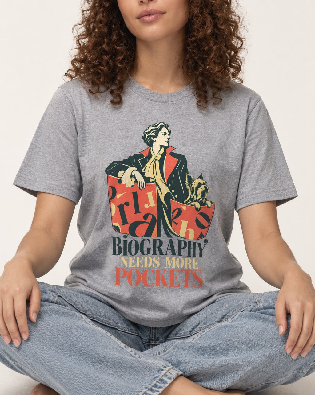Yorkshire Terrier Biography Needs More Pockets Literary Portrait Graphic T-Shirt in Sport Grey, worn by a seated model