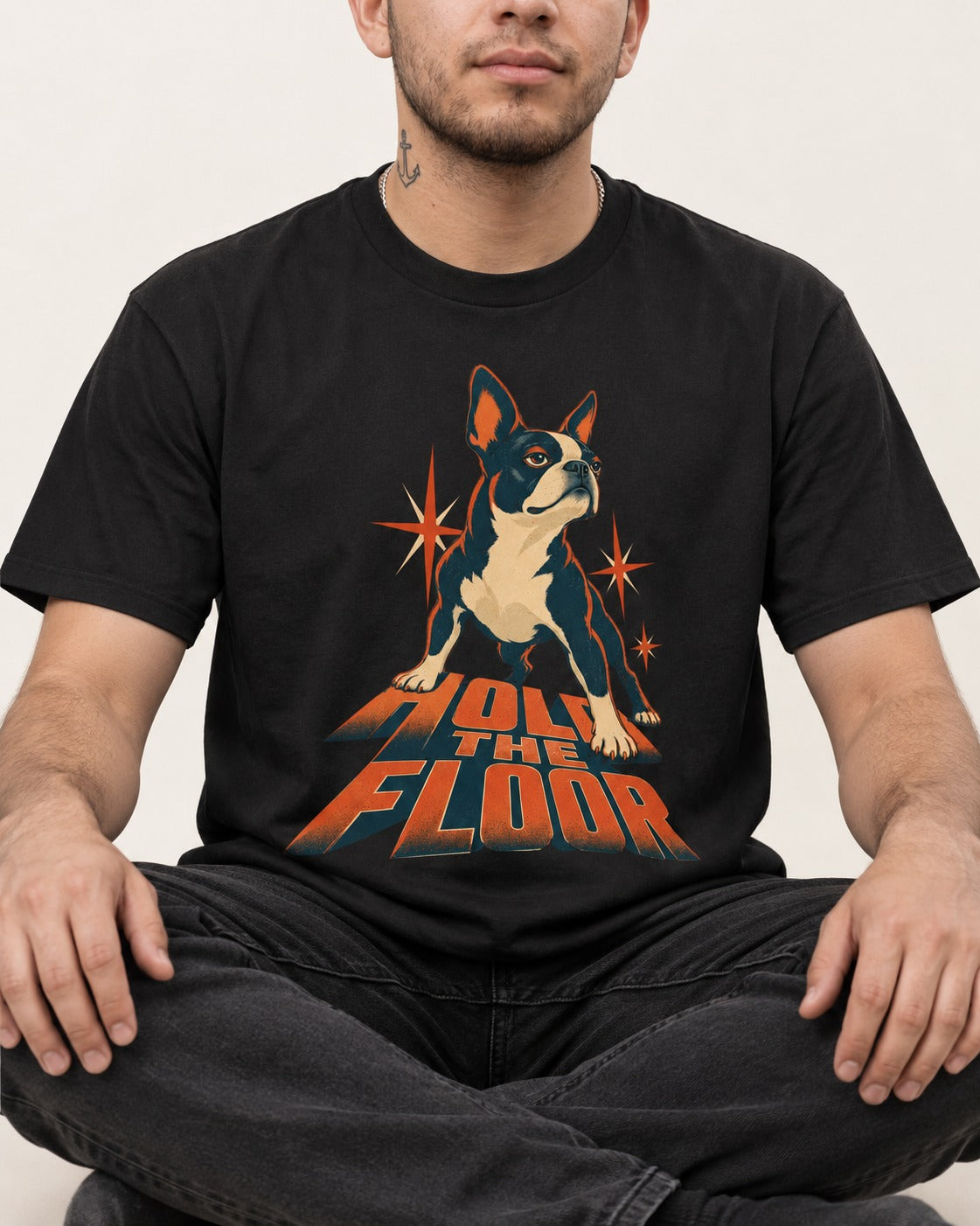 Boston Terrier On The Floor Perspective Graphic T-Shirt in Black, worn by a seated model